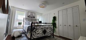 a bedroom with a black bed and a white closet at LUXE BROOKLYN Getaway in Brooklyn