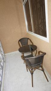 two chairs sitting next to a wall with a window at Jakicha Motel in Dar es Salaam