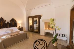 庫特羅菲亞諾的住宿－卡西納巴德西亞旅館，一间卧室配有一张床、一张桌子和一面镜子