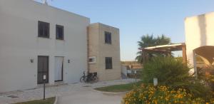 a white building with a clock tower on the side of it at Al Covone-1 - Residence Burrone in Favignana