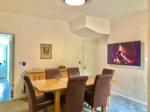 a dining room with a wooden table and chairs at Garden Villa in Stafford