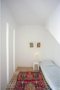 een slaapkamer met een bed en een tapijt op de vloer bij Unique Architect's House in Essaouira