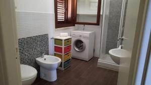 a bathroom with a washing machine and a washer and dryer at Al Covone-1 - Residence Burrone in Favignana