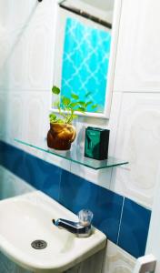 ein Badezimmer mit einem Glasregal über einem Waschbecken in der Unterkunft LA Perla Sabanera CTG in Cartagena de Indias