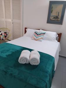 a bedroom with a bed with two towels on it at LA Perla Sabanera CTG in Cartagena de Indias