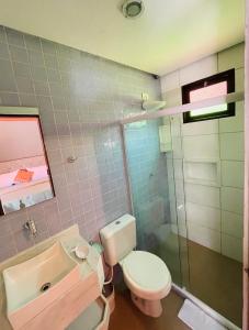 a bathroom with a toilet and a sink and a shower at Pousada Tarumim in Vale do Capao