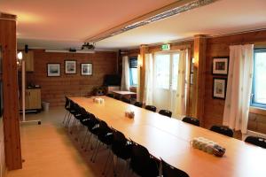 una gran sala de conferencias con una mesa larga y sillas en Ljosland Fjellstove en Ljosland