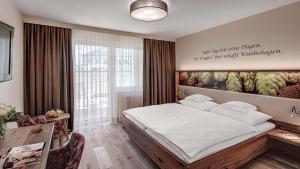 ein Schlafzimmer mit einem Bett und einem Gemälde an der Wand in der Unterkunft Hotel Almesberger in Aigen im Mühlkreis + 37 Fotos