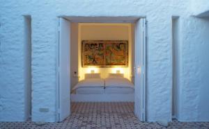 a bedroom with a bed and a painting on the wall at Unique Architect's House in Essaouira
