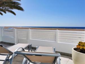 2 Stühle und ein Tisch auf einem Balkon mit Meerblick in der Unterkunft Luxury Apartment On The Beach in Playa Honda