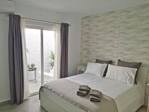 Un dormitorio con una cama grande con dos zapatos. en Luxury Apartment On The Beach, en Playa Honda