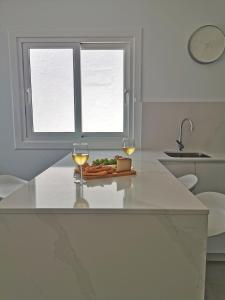 eine Küche mit zwei Gläsern Wein und einem Teller Essen in der Unterkunft Luxury Apartment On The Beach in Playa Honda