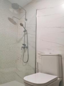ein weißes Bad mit einer Dusche und einem WC in der Unterkunft Luxury Apartment On The Beach in Playa Honda + 17 Fotos
