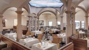 un ristorante con tavoli e sedie bianchi e un soffitto blu di Hotel Almesberger ad Aigen im Mühlkreis