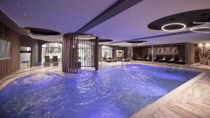 ein großer blauer Pool in der Mitte eines Raumes in der Unterkunft Hotel Almesberger in Aigen im Mühlkreis