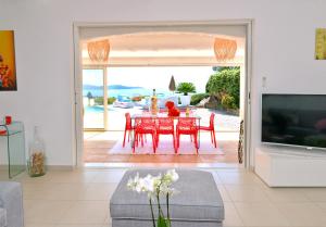 a living room with a table and a large sliding glass door at VILLA JUCANOS - Vue mer panoramique Golfe de St-Tropez in Cavalaire-sur-Mer