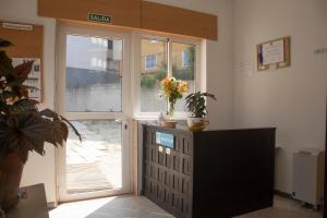 Habitación con puerta, planta y TV en Albergue Santa Olaia, en Silleda