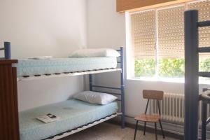 a room with two bunk beds and a window at Albergue Santa Olaia in Silleda