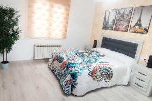 um quarto com uma cama com um cobertor colorido em Estrenar! Con PINBALL + 8 min ayto + 2 habs 1.50 em Oviedo