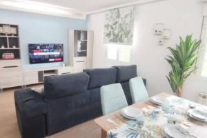 uma sala de estar com um sofá azul e uma mesa em Estrenar! Con PINBALL + 8 min ayto + 2 habs 1.50 em Oviedo