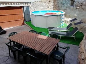 un patio con mesa, sillas y piscina en El Canchal de Eladia, en Valdeverdeja