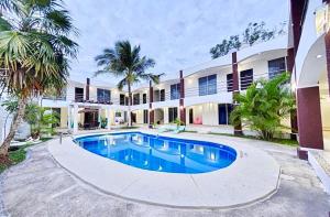 an exterior view of a house with a swimming pool at Hotel España in Chetumal