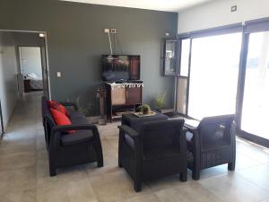 a living room with two chairs and a tv at sueño del chocon in Villa El Chocón