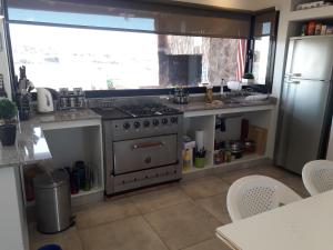 a kitchen with a stainless steel stove and a window at sueño del chocon in Villa El Chocón +13 photos
