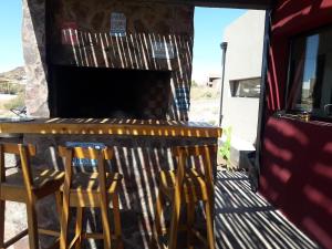 a bar with two stools and a fireplace at sueño del chocon in Villa El Chocón