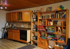 a kitchen with wooden shelves with books at Hostel Bad Salzig in Boppard