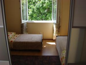 a small room with two beds and a window at Apartments Marija in Trogir