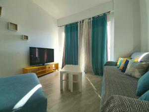a living room with a couch and a tv at Alba Apartments in Sarandë