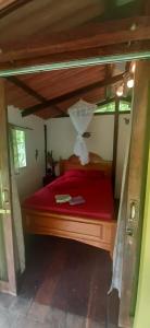 um quarto com uma cama vermelha com uma estrutura em madeira em Casita Rio Indio em Nombre de Dios