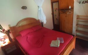 a bedroom with a large red bed with a pink sheets at Casita Rio Indio in Nombre de Dios