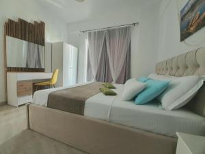 a bedroom with a large bed with blue pillows at Alba Apartments in Sarandë