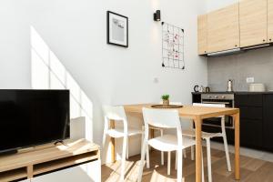 cocina y comedor con mesa de madera y sillas en ALTIDO Contemporary apartments in historical Giambellino-Lorenteggio, en Milán