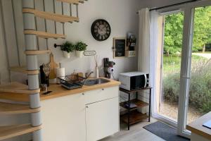 una cocina con fregadero y un reloj en la pared en Les Genêts, en Fontaine-sous-Jouy