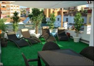 eine Gruppe von Stühlen und Tischen auf einem Balkon in der Unterkunft Blue Beach House ATICO CON TERRAZA in Málaga