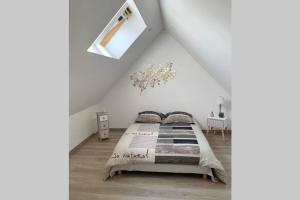ein Schlafzimmer mit einem Bett im Dachgeschoss in der Unterkunft Les Genêts in Fontaine-sous-Jouy