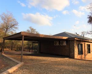 a building with a roof on the side of it at Locust Retreat Immaculate 2bedroom cottage in Marloth Park