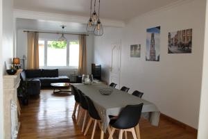 een woonkamer met een tafel en stoelen en een bank bij Vakantiewoning 't Kartuis, Brugge in Brugge