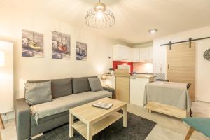 a living room with a couch and a table at Bourg Saint Maurice Centre 45m2 prox Gare SNCF et Funiculaire in Bourg-Saint-Maurice