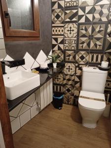 a bathroom with a sink and a toilet and tiles at La Herrerita in Candelario +2 photos
