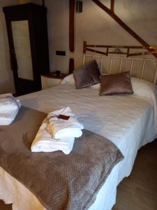 Un par de toallas están en una cama en La Herrerita, en Candelario