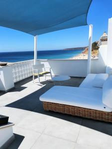 a balcony with a bed and a view of the beach at Casa Celeste by Sevencollection in Salema