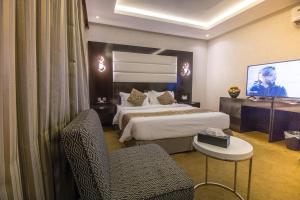 a hotel room with two beds and a flat screen tv at Golden Garden Serviced Apartments -King Faisal Dt in Riyadh