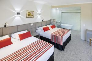 Una habitación de hotel con dos camas y un baño. en Cassino All Inclusive Resort Poços de Caldas By Nacional Inn, en Poços de Caldas
