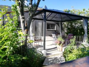 une véranda avec un auvent bleu et un arbre dans l'établissement entre mer et montagne, à Peyroules