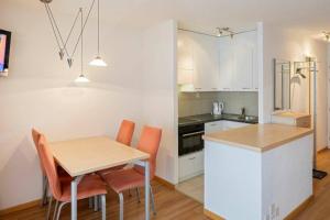 - une cuisine avec une table et des chaises dans la chambre dans l'établissement Cristal 50, à Loèche-les-Bains
