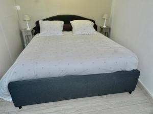 a bedroom with a large bed with white sheets and pillows at LE SEUIL in Chartres